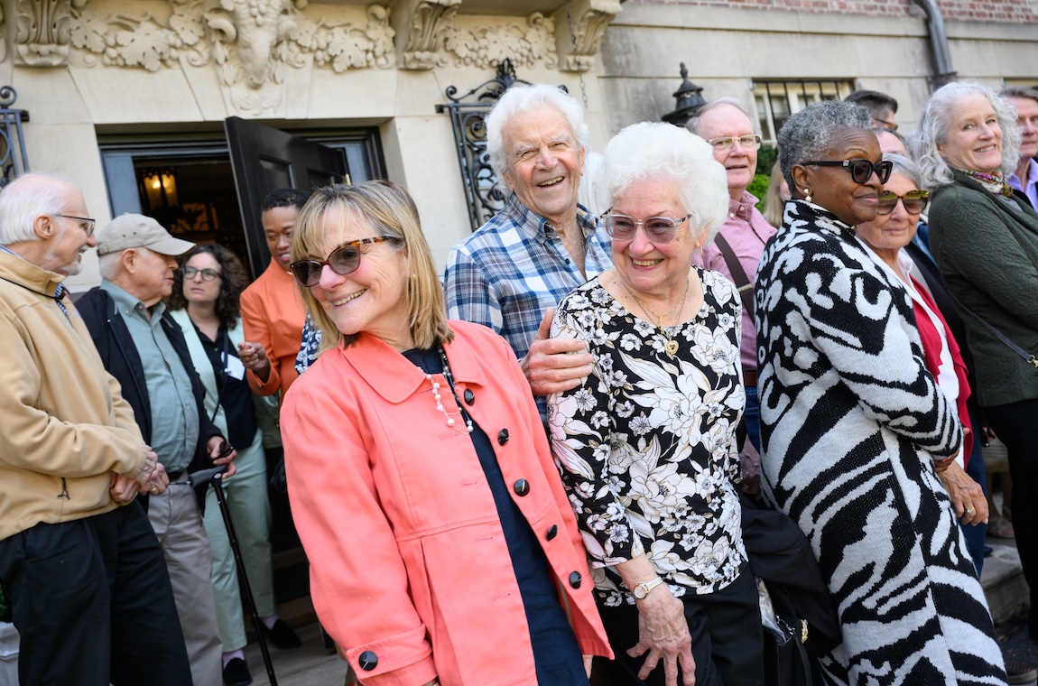 Attendees stand outside, preparing to take a group photo